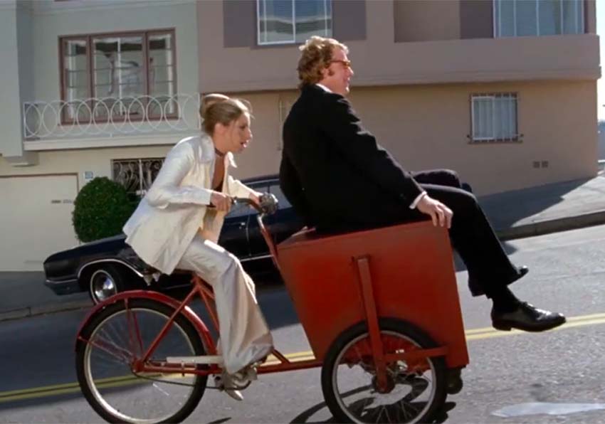 Imatge del esdeveniment:Una dona amb bicicleta portant davant en un calaix a un home